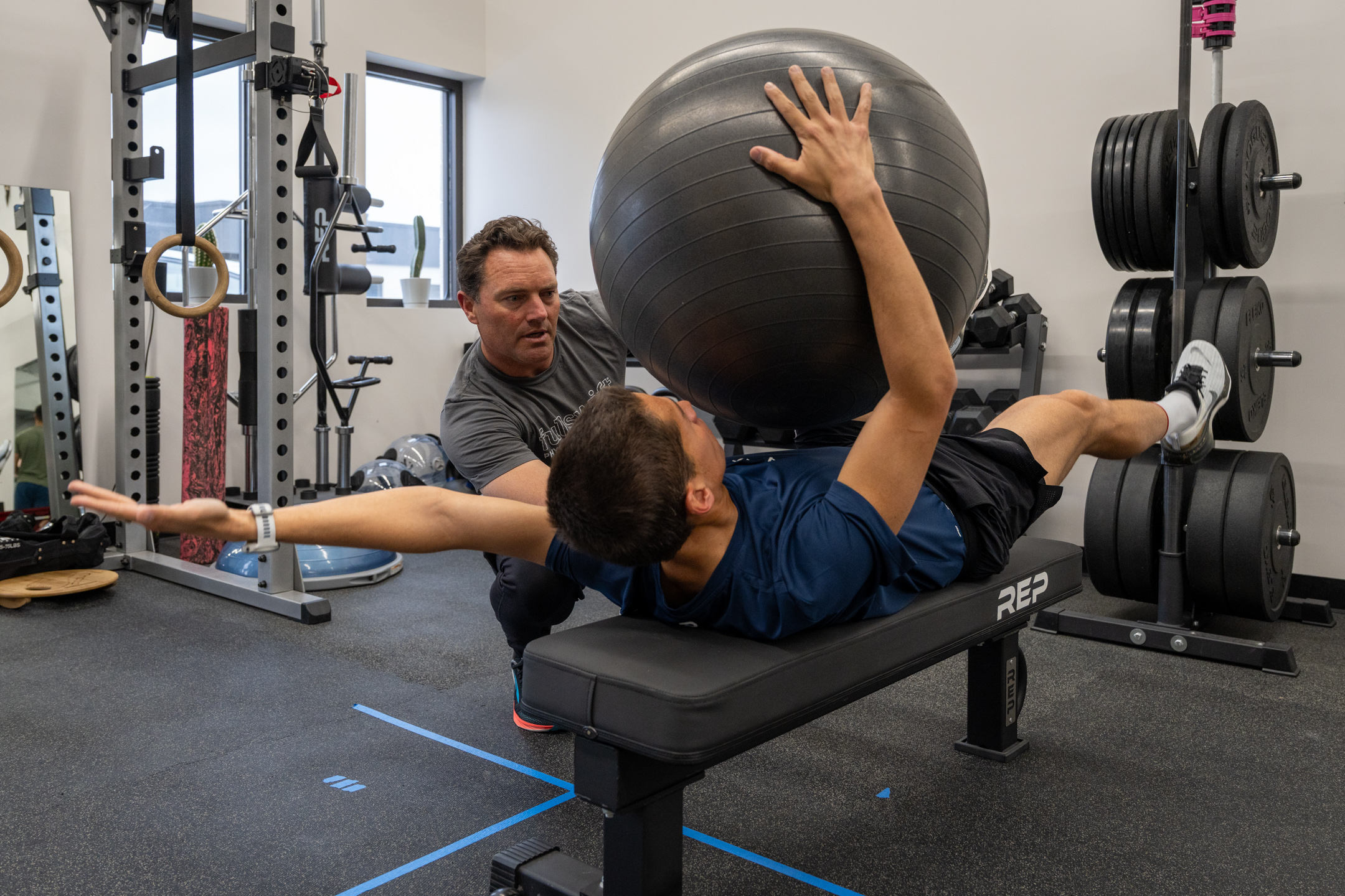 athlete completing a movement assessment with a physical therapist in a performance training setting