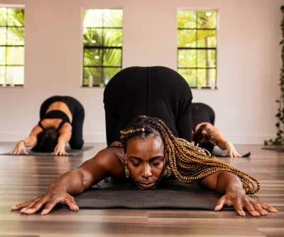 woman in black tank top and black leggings doing yoga